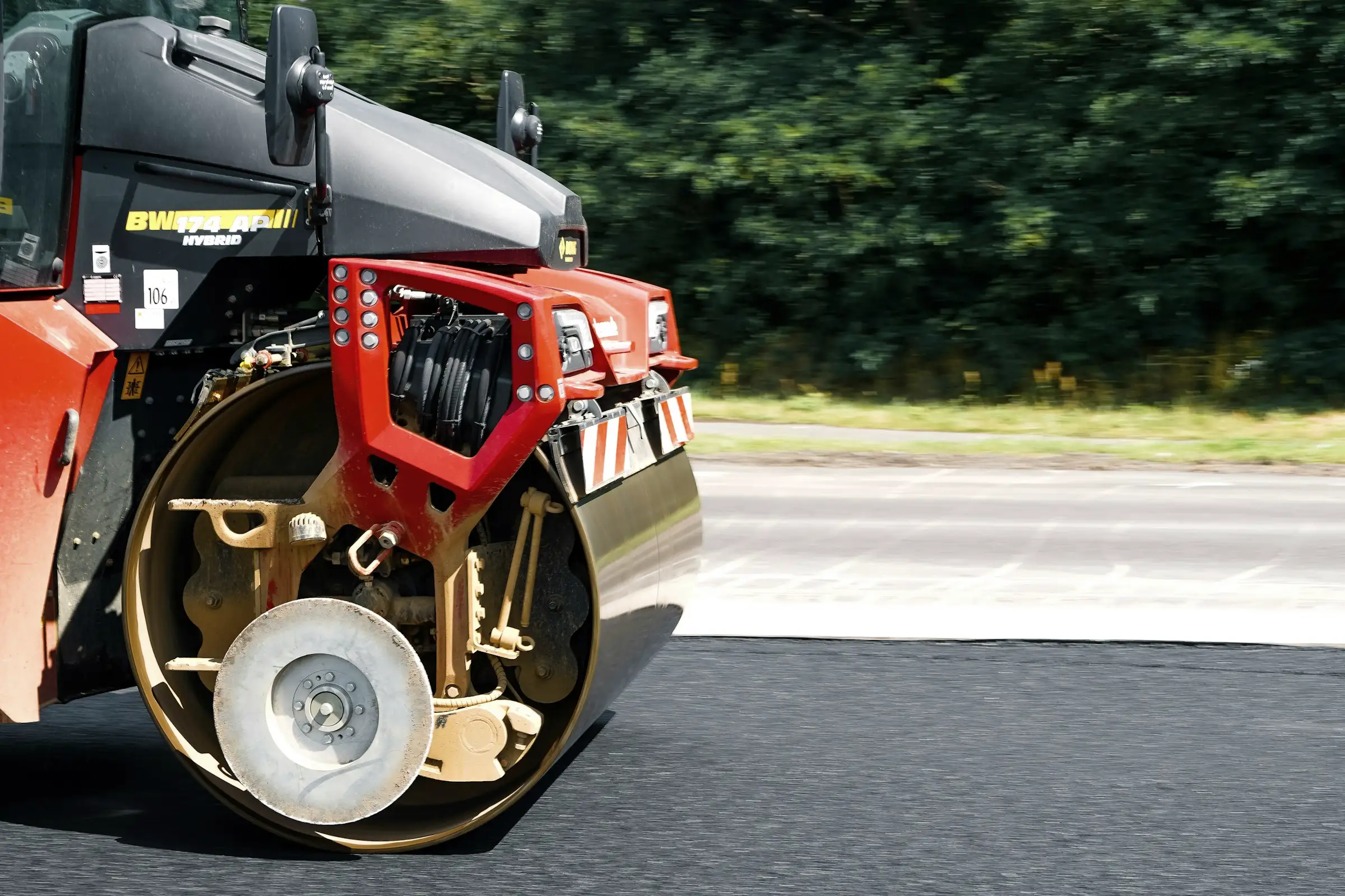 Close view of a tandem road roller compacting freshly laid asphalt